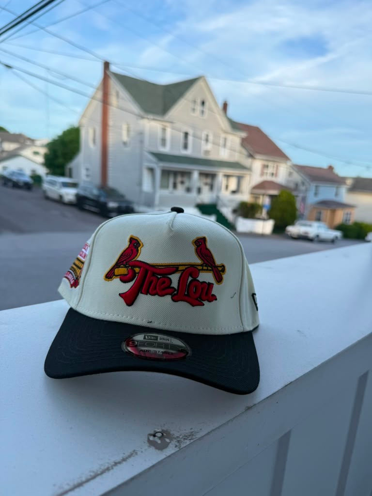 Gorra snapback New Era 9FORTY de los St. Louis Cardinals con un diseño en color crema y negro que presenta el texto "The Lou".