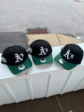 Gorra es una New Era 9FORTY A-Frame ajustable de los Oakland Athletics, que presenta una corona negra y visera verde con un parche lateral de la Serie Mundial de 1989.