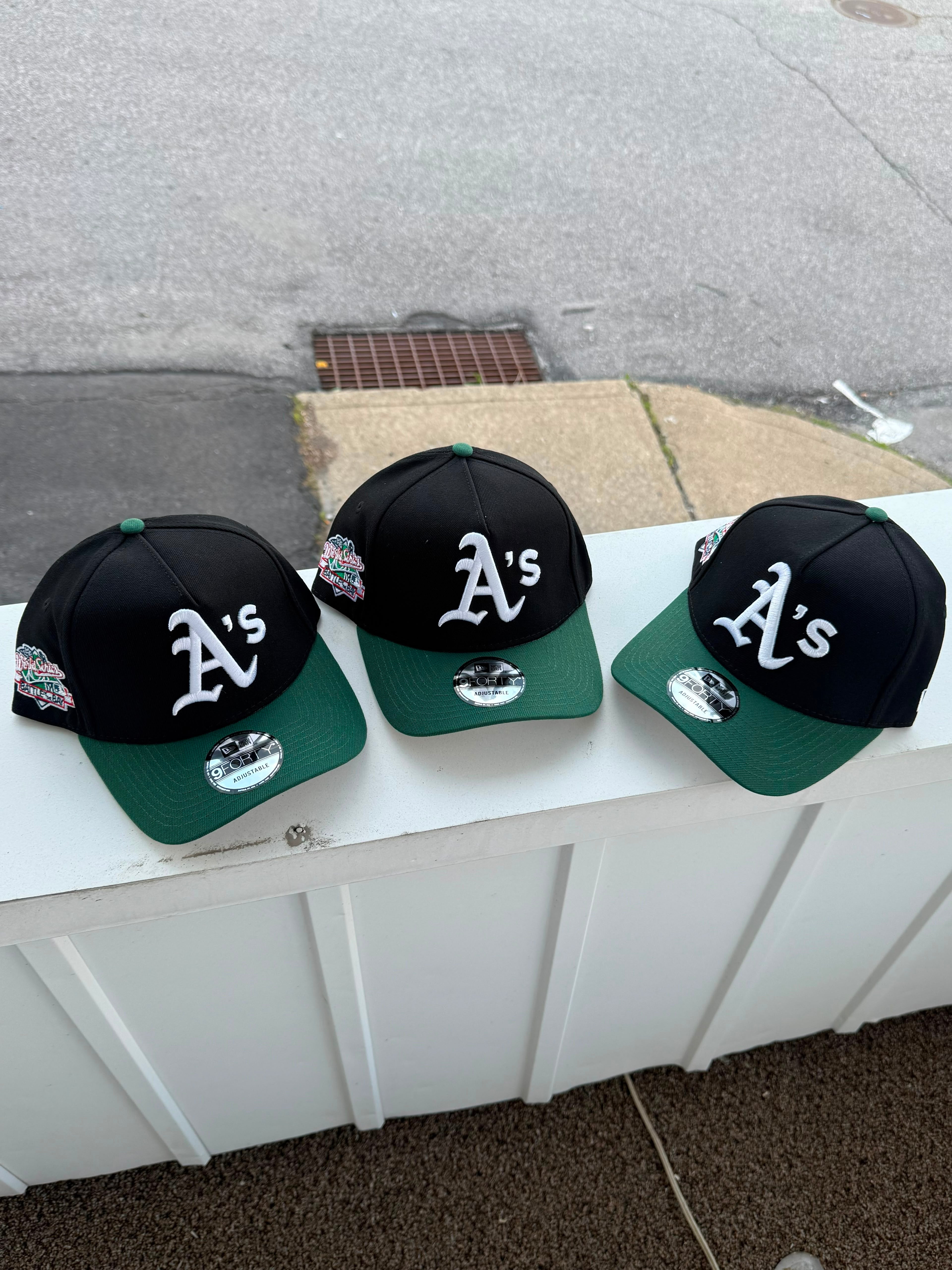 Gorra es una New Era 9FORTY A-Frame ajustable de los Oakland Athletics, que presenta una corona negra y visera verde con un parche lateral de la Serie Mundial de 1989.