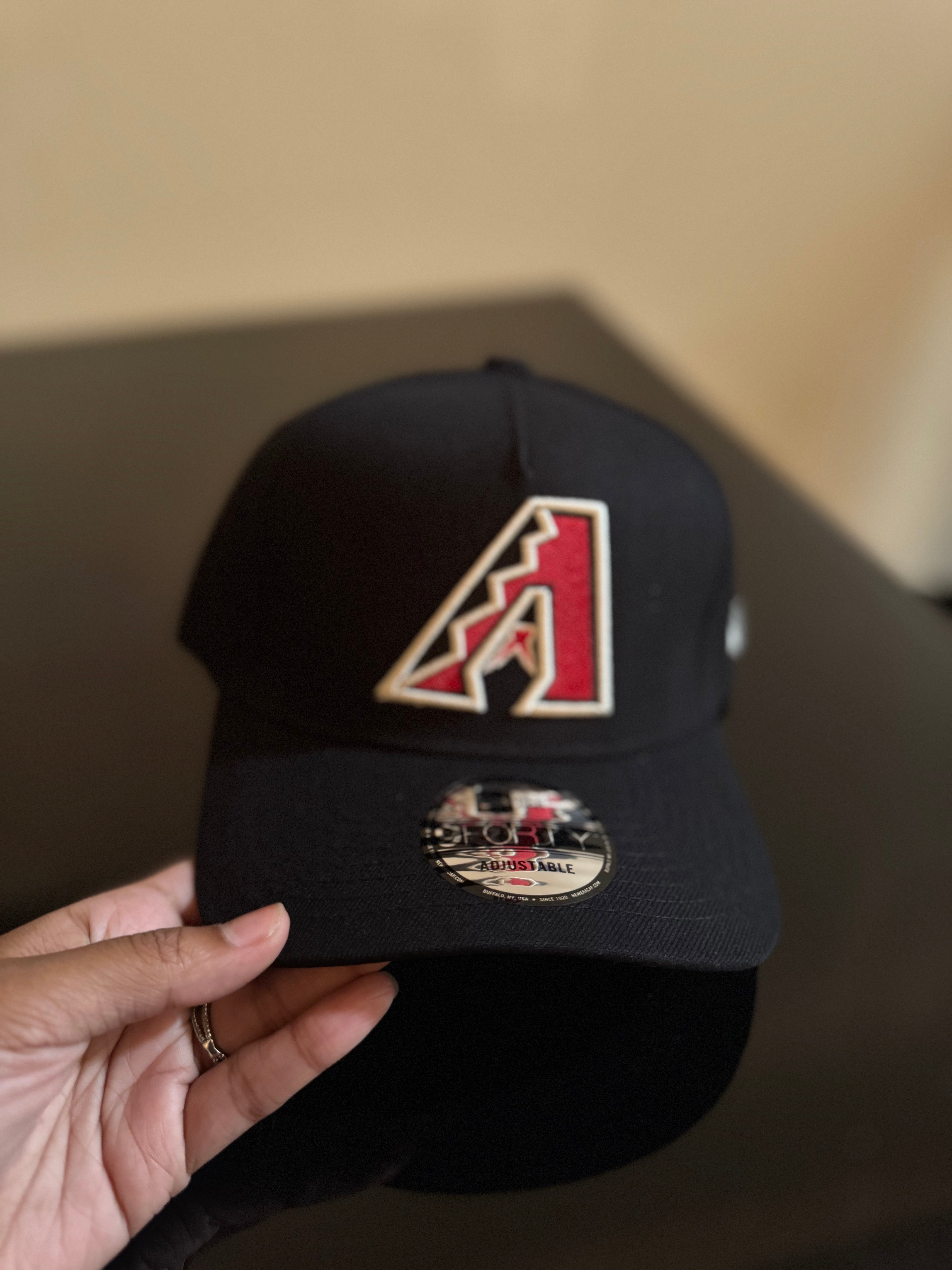 Gorra New Era 9FIFTY ajustable en color negro con el logotipo bordado de los Arizona Diamondbacks.