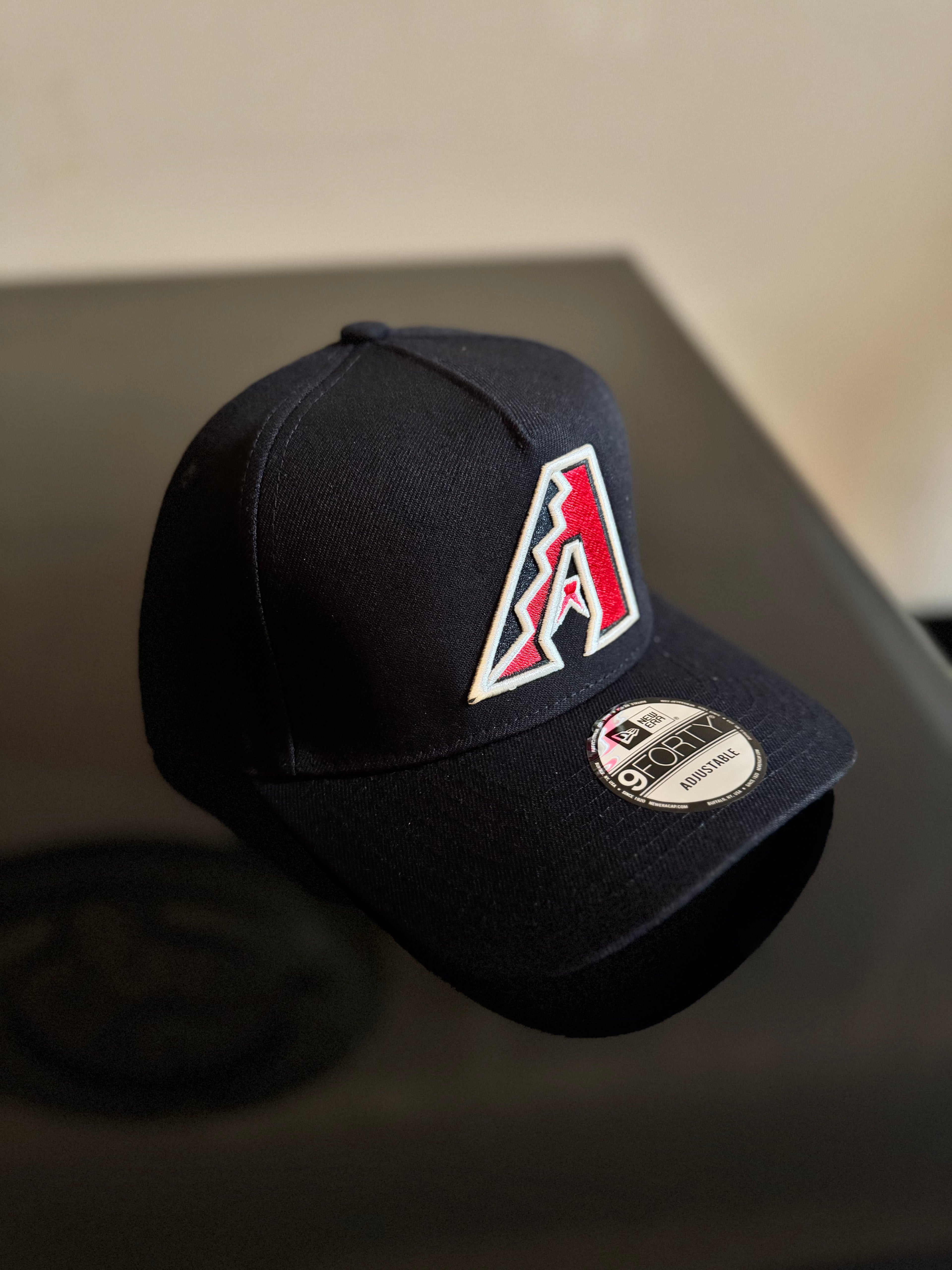 Gorra New Era 9FIFTY ajustable en color negro con el logotipo bordado de los Arizona Diamondbacks.